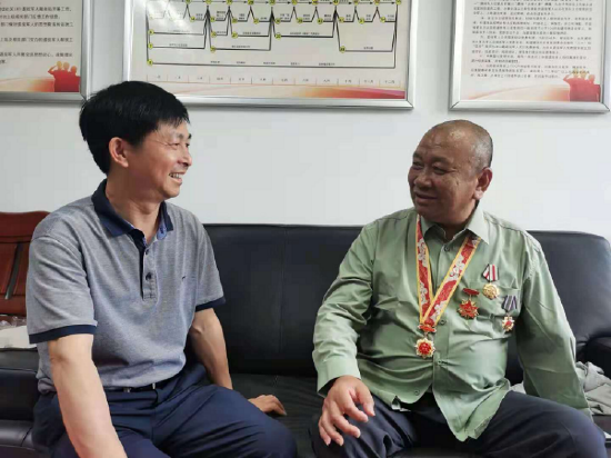 熊志中在街道服务站与一等功臣王文仓交谈