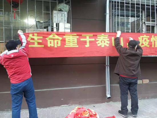 走街串巷做宣传冒着严寒挂条幅战疫情6旬老党员不输年轻人