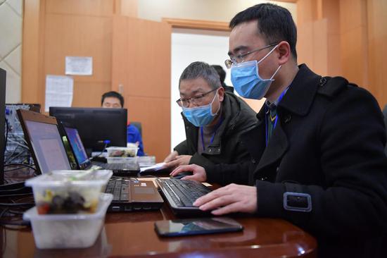 在南昌"抗疫"指挥部,工作人员正在加班加点工作,桌上的盒饭还没有打开