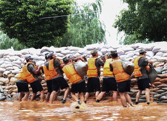 2020年7月14日,解放军战士正在江西九江庐山市南康堤抗洪抢险加固子堤