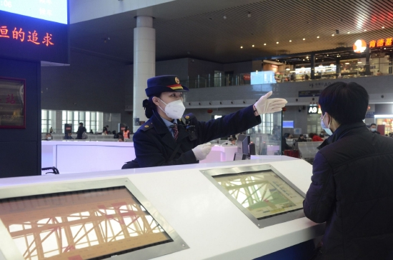 赣闽两省往返香港旅客列车4月1日起恢复开行。图为南昌站“红土情”客运员刘洋在回答旅客问询。刘慕 摄