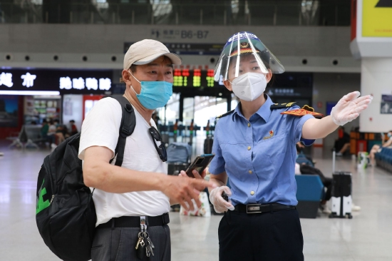 南昌站客运值班员正在引导旅客。（张杰 摄）