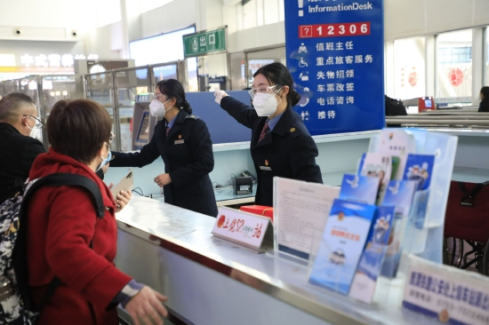 图为上饶站服务台工作人员为旅客指明乘车方向。 胡钧 摄