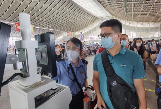 厦门站客运员协助旅客做好过闸机验票。(万宇供 摄)