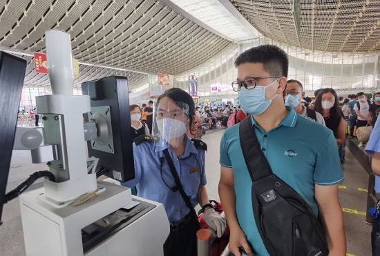 厦门站客运员协助旅客做好过闸机验票。（万宇供 摄）