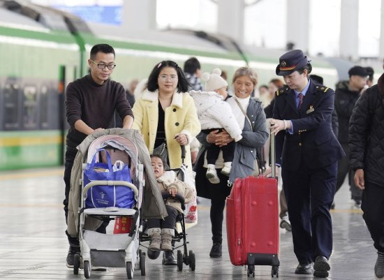 九江站客运值班员正在帮助下车的旅客推拿行李。代建力 摄