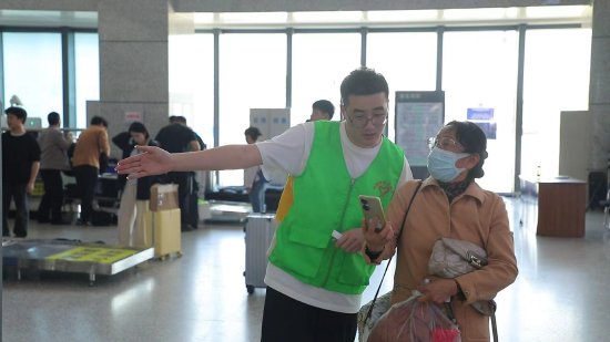 景德镇北站增派志愿者在候车厅为旅客提供引导服务。（余清清 摄）