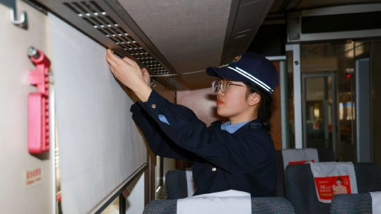 福州动车段动车组机械师正在对窗帘状态进行检查。（谭文卿摄）