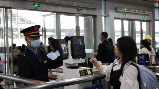 宜春站客运员为人工通道口的旅客核验车票信息。（左嘉慧 摄）