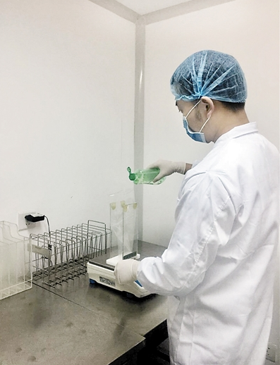 检验人员取样. 用于比较实验的样品.本报记者 胡杰 摄