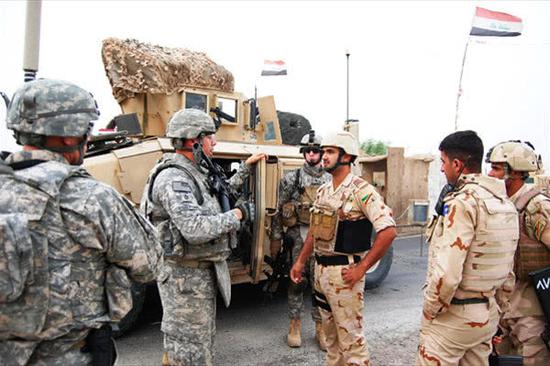 驻伊美军军官与伊拉克政府军士兵交流。