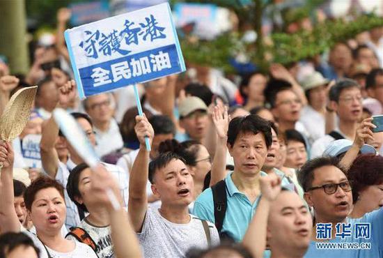 7月20日，在香港添马公园，市民举起“守护香港”的标语。新华社记者 王申 摄