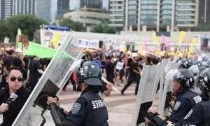 而公安干警们则对“示威者”施放催泪弹，同时出动警犬协助驱散。