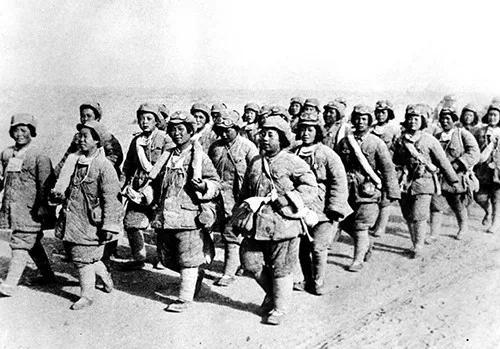 1949年第一野战军进军新疆时，行进在戈壁滩上的女战士。图|新华社