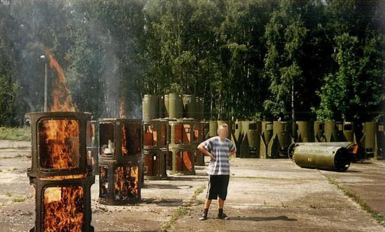 图为熊熊燃烧的"飞毛腿"弹体.叉腰男子的表情大抵是无奈的.