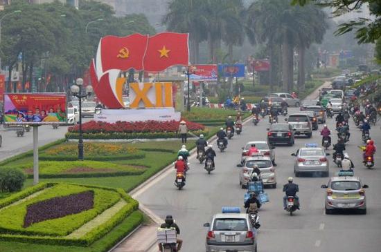 越南首都河内许多街道挂上国旗和党旗,主要路口摆放花卉,宣传画和标语