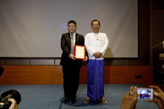       12月30日，中信联合体代表、中信建设有限公司总经理陈晓佳（左）展示缅甸皎漂特别经济区工业园和深水港项目的中标通知书。新华社发
