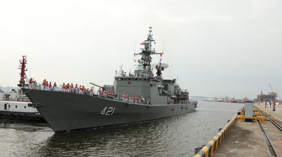 离舰登岸,与前来迎接的南部战区海军政治工作部副主任张伯硕少将握手