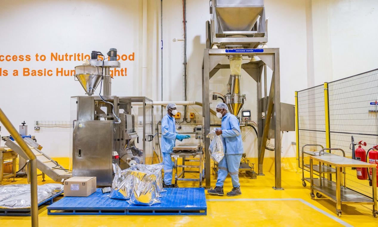 坦桑尼亞達累斯薩拿姆的營養素預拌材料工廠，工人們正從出料站卸下預拌材料，準備進行密封和包裝。Sanku的聯合創始人費力克斯・布魯克斯-丘奇表示：「我們一直以來的目標是在2030年前惠及一億人。」©Rolex/Peter Ndung‘u