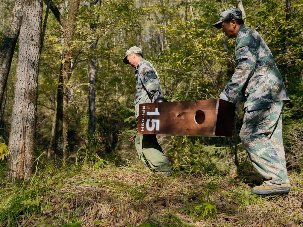  護區工作人員正將人工巢箱搬運進森林。 © Rolex/Zhezhou Fu