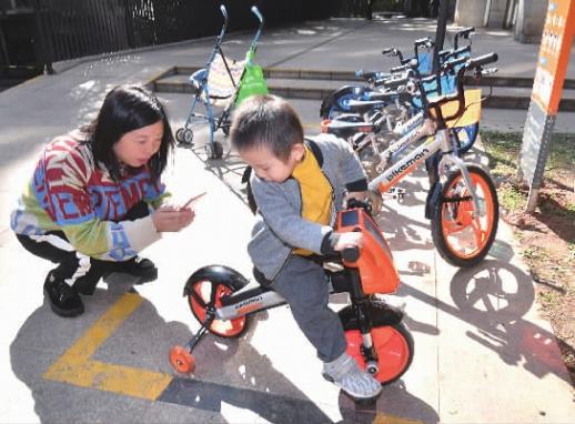 11月1日，长沙市天心区城市森林小区，一位家长用手机扫码给孩子取“儿童版”共享单车。记者 田超 摄