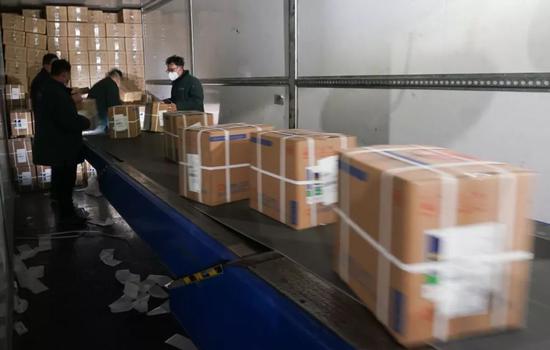 1月27日，武汉邮区中心局邮件处理中心的职工在卸货分拣援助物资（图源：新华社）