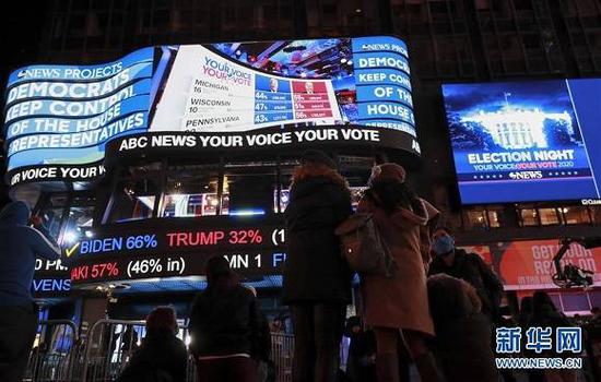 （图片说明：11月3日，人们在美国纽约时报广场观看实时计票结果。来源：新华社记者 王迎 摄）