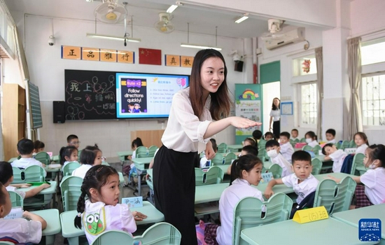 深圳市福田区南园小学教师、香港理工大学对外汉语教育专业硕士毕业的香港青年黄晓蕾在英语课上与孩子们互动(9月1日摄)。新华社记者 毛思倩 摄