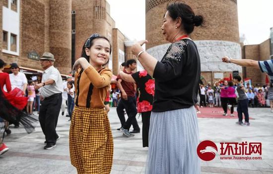  7月4日，新疆乌鲁木齐。位于二道桥地区的新疆国际大巴扎和步行街，当音乐响起，各族人民载歌载舞。崔萌 摄