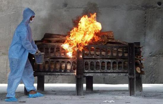  印度一火葬场工作人员泼洒可燃液体