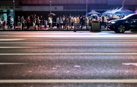 7月28日，南京街头一处核酸检测点，市民在夜色中排队，准备进行核酸检测取样。这是南京市第三轮全员核酸检测。摄影/本刊记者 泱波