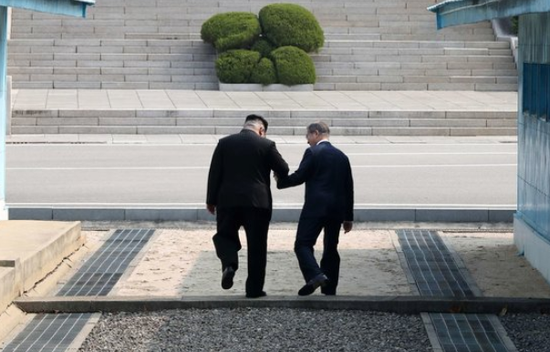 朝韩领导人手拉手跨过水泥军事分界线。（纽西斯通讯社）