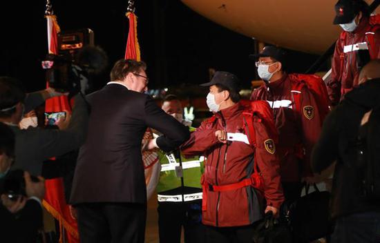 3月21日，在塞尔维亚首都贝尔格莱德，前来迎接的塞尔维亚总统武契奇（左）与中国援助塞尔维亚抗疫医疗专家组成员“碰肘”致意。