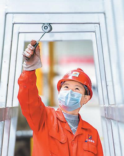 在湖北亿钧耀能新材股份公司车间，工人对生产线涂刷油漆除锈作业。黄志刚摄（人民图片）