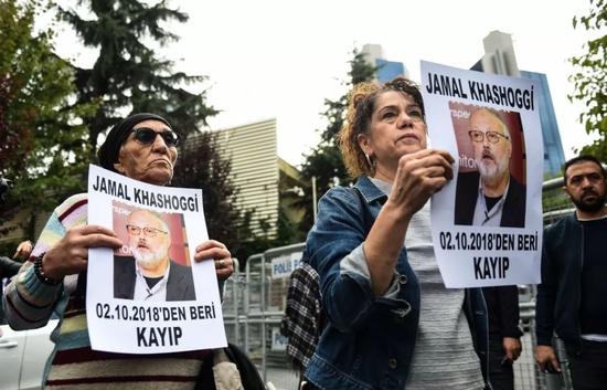 10月9日，在土耳其伊斯坦布尔，抗议者举着“失踪”记者贾迈勒·卡舒吉的照片在沙特驻伊斯坦布尔领事馆门口示威。（新华社/法新）