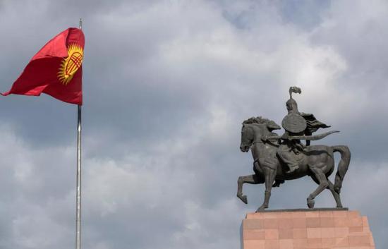 这是6月9日在吉尔吉斯斯坦首都比什凯克的阿拉套广场拍摄的吉尔吉斯斯坦国旗和玛纳斯雕像。新华社记者 费茂华 摄