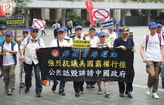 示威人士手持“抗议美国霸权”、“违反国际法规”等标语。（图片来源：香港“东网”）