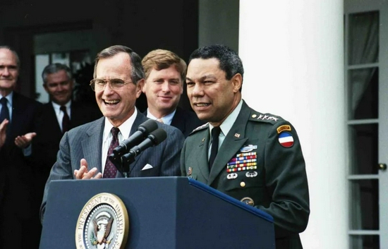 穿着军装的鲍威尔,和老布什站在话筒前.