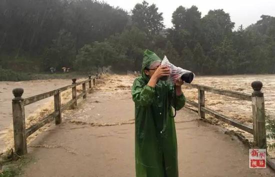新华社记者刘军喜冒雨拍摄洪水肆虐的安徽宣城。