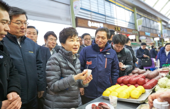  2016年春节前，朴槿惠视察传统市场，与小贩交谈。