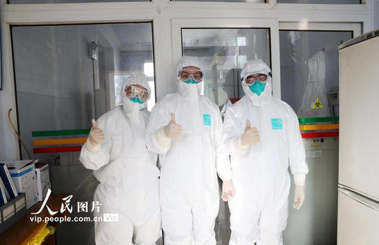 2020年1月29日，正月初五，重庆市黔江区疾控中心“90后”医生钟璐（中）、殷全琨（右一）和张洪为在进检验室前合影。