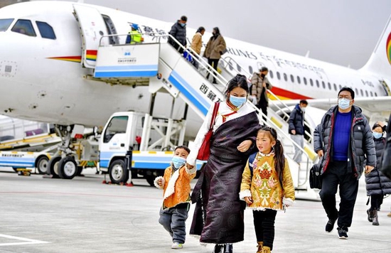 在拉萨贡嘎国际机场，乘客走下飞机（2021年12月30日摄）。新华社记者 张汝锋 摄