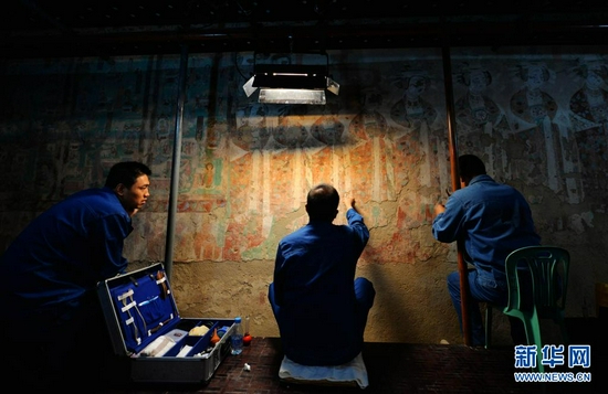  敦煌研究院技术人员在莫高窟98窟内对病害壁画进行修复（2014年9月3日摄）。新华社记者 陈斌 摄