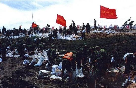 28发消灭23个敌人 一面面鲜红的战旗在战火洗礼中傲然挺立 △该部队官兵参加98长江抗洪抢险行动。