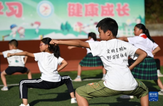  在陕西省安康市平利县老县镇中心小学的操场上，学生们在课后参加武术社团活动（2020年9月7日摄）。新华社记者 李一博 摄