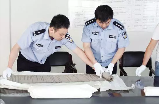 一张神秘照片引发的惊天大案 剧情可以写成连续剧 ↑办案民警查看文书