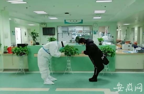 2月23日,在武汉一重症病区,治愈出院的蒋女士向安徽支援湖北医疗队专家鲁朝晖鞠躬致谢。
