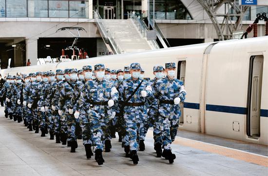  2020年2月17日，军队增派支援武汉抗击新冠肺炎疫情的又一批1200名医务人员，分别通过航空和铁路输送抵达武汉。图为医疗队员抵达武汉汉口火车站后军容严整地走出车站。 解放军报记者 王传顺/摄