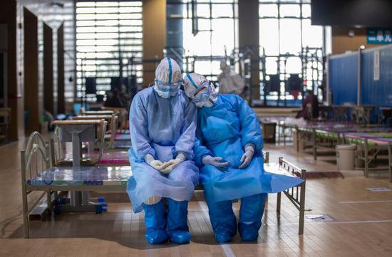 3月10日，两名青海医疗队队员在武昌方舱医院等待出舱时小憩。