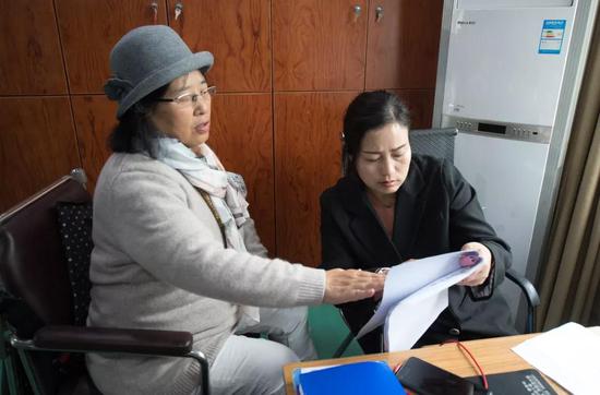 4月11日，吴素环（左）在中国盲文图书馆桐庐县支馆与工作人员讨论电影《可可西里》的解说稿。